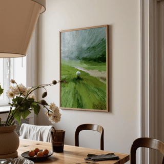 Abstract green wall art in a dining room showing a golf ball on a tee with a wooden frame and a table with flowers