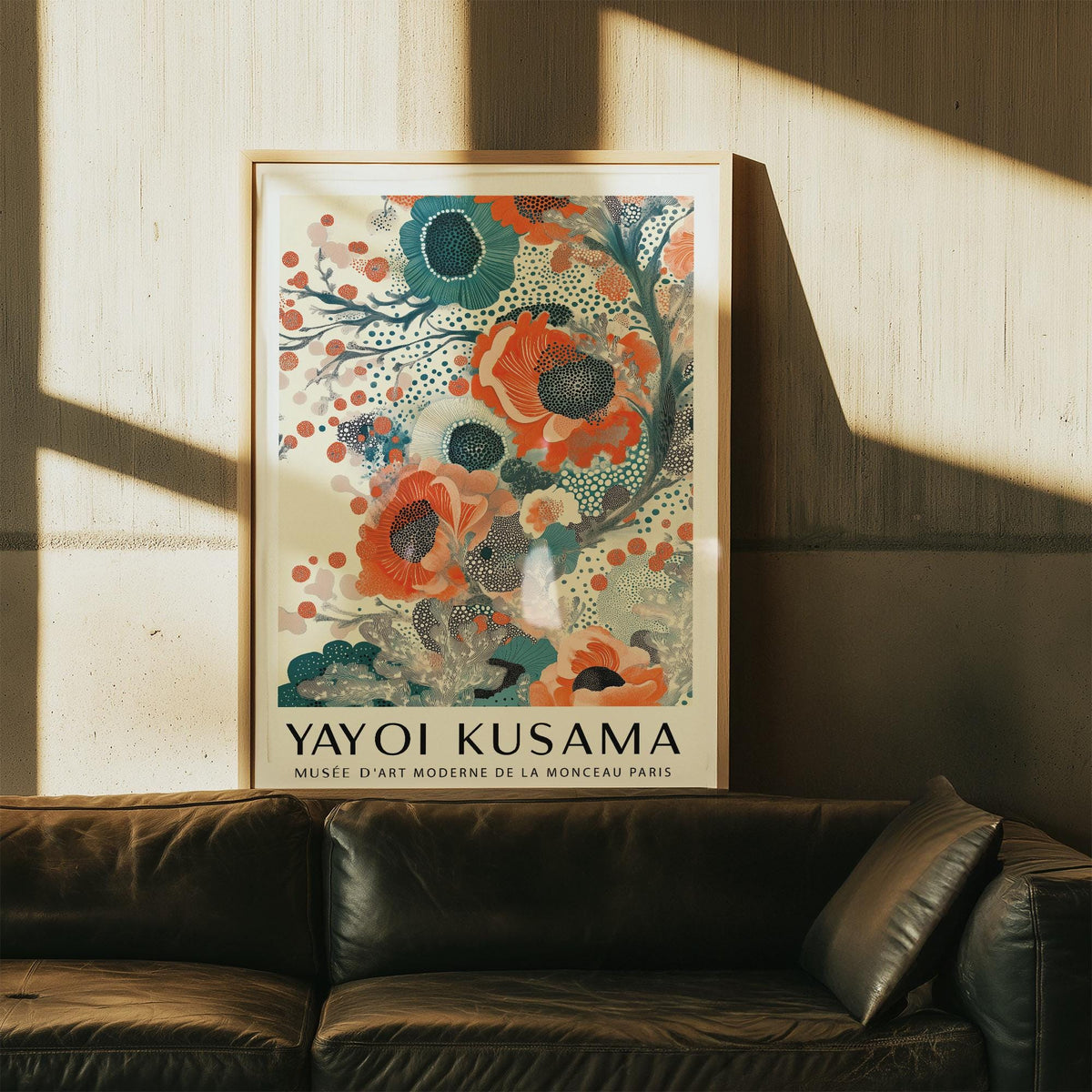 Print leaning on wall of stylized teal and orange floral blooms above a dark sofa