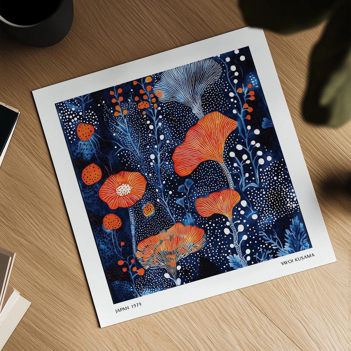 Abstract Flower Art print with coral dots and blue floral illustration on a wooden surface near a black cup