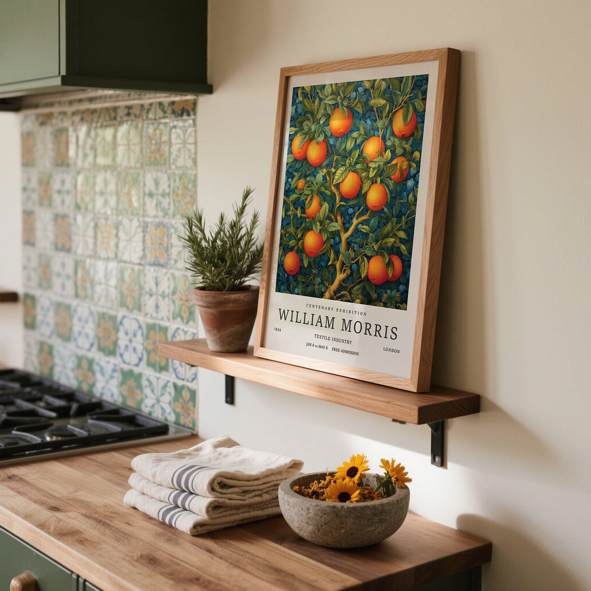 Orange Tree wall art leaning on shelf with a potted rosemary plant in a kitchen