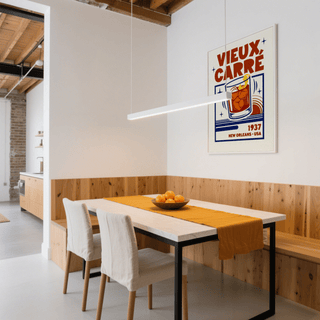 New Orleans Cocktail Print on wall above dining table with yellow runner and bowl of oranges