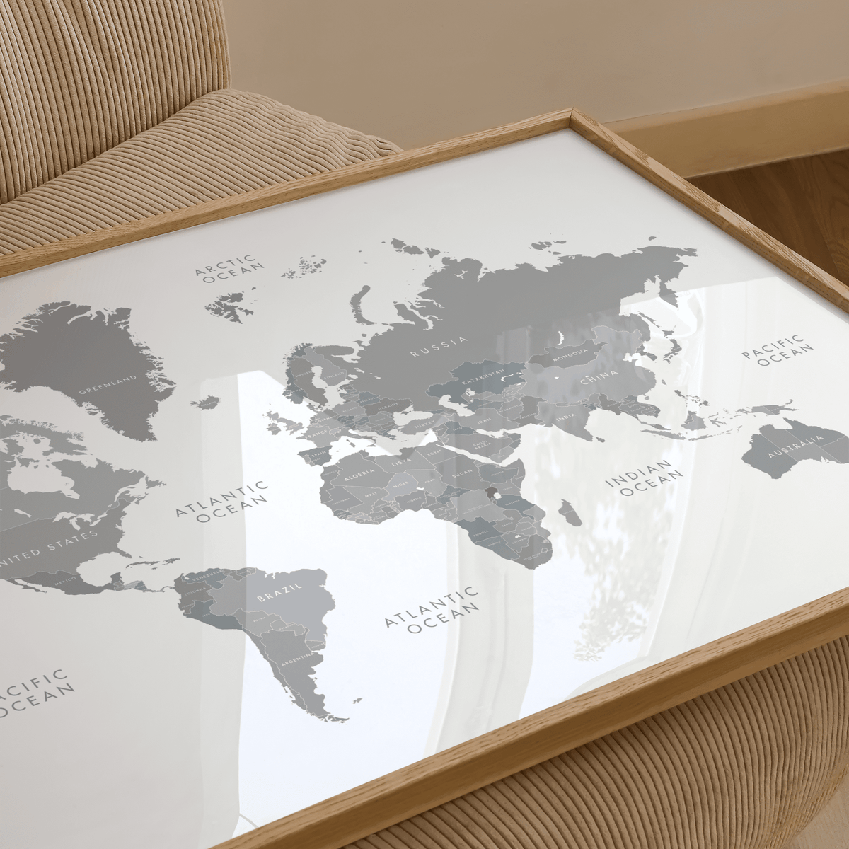 Close-up of world map art showing grey countries with white background on a corduroy chair