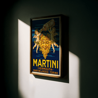 Framed Vintage Vermouth Poster with grape face and cherubs in warm lighting on a wall