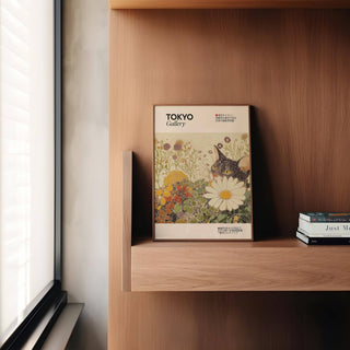 Print of a tuxedo cat and flowers in soft botanical tones leaning on a wooden shelf beside stacked books