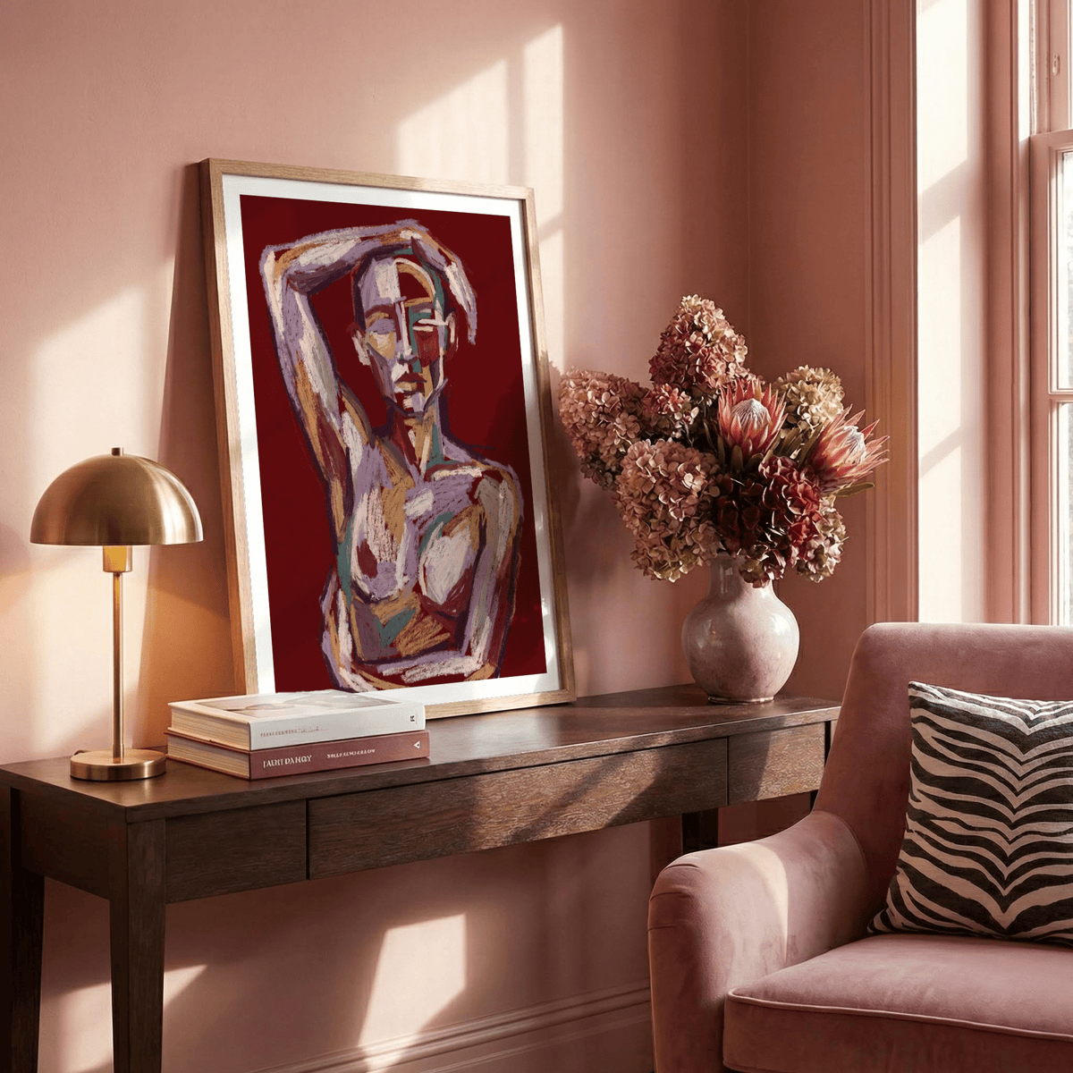 Print leaning on a dark wood table with Contemporary Figure Art of an abstract human figure in muted tones and deep red background