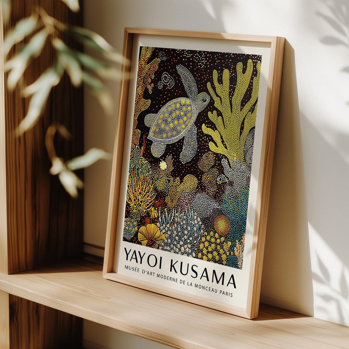 Framed sea turtle wall art with bright abstract coral detail leaning on wooden shelf
