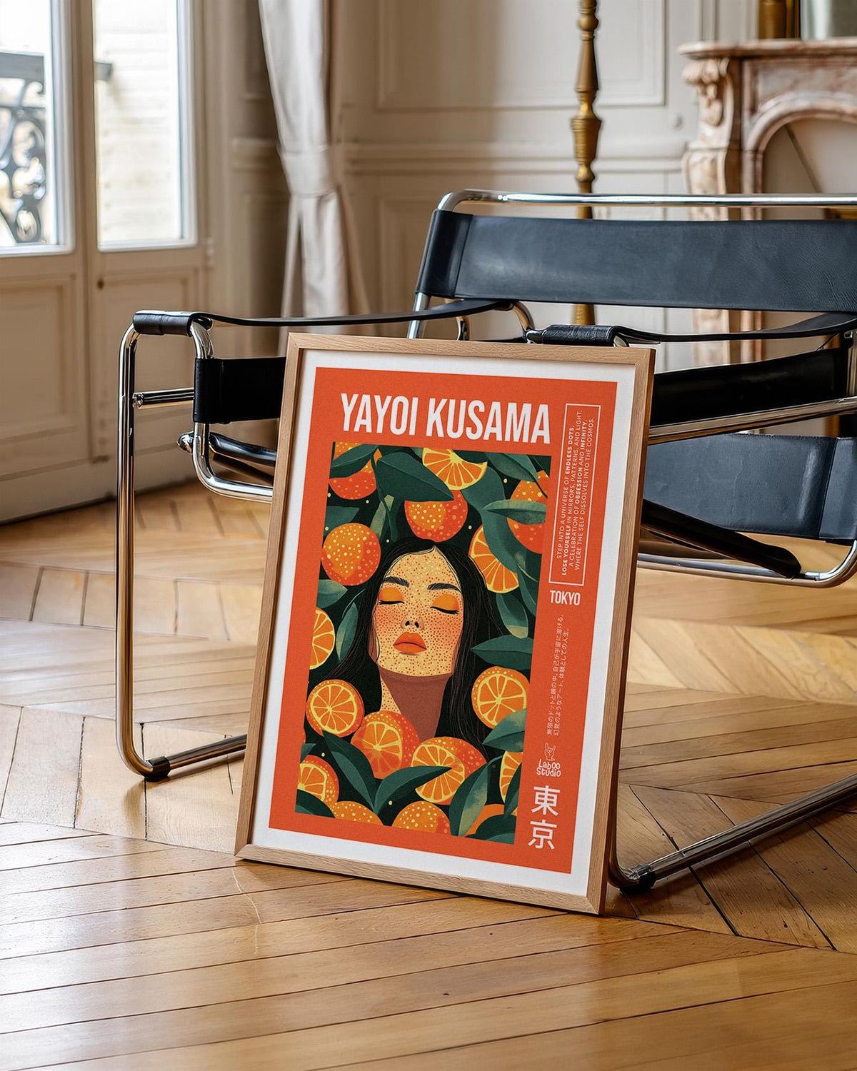 Cool wall art print leaning on a wooden floor by a modern black chair with a metal frame