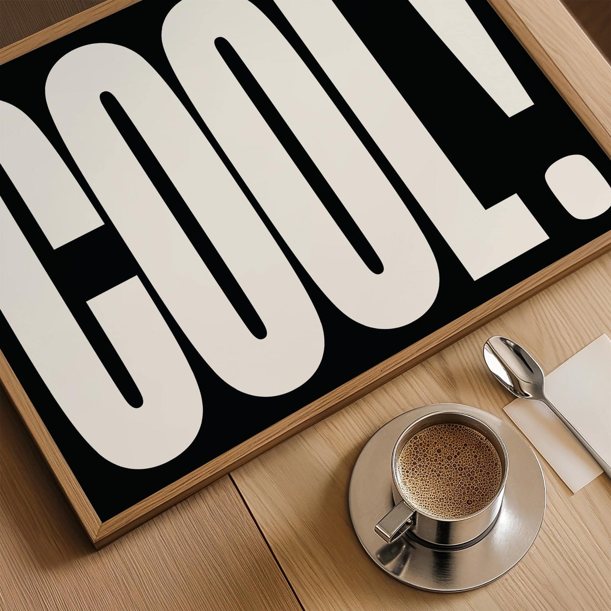 Close-up of Cool Typography Art with black background and white bold letters beside a cup of coffee