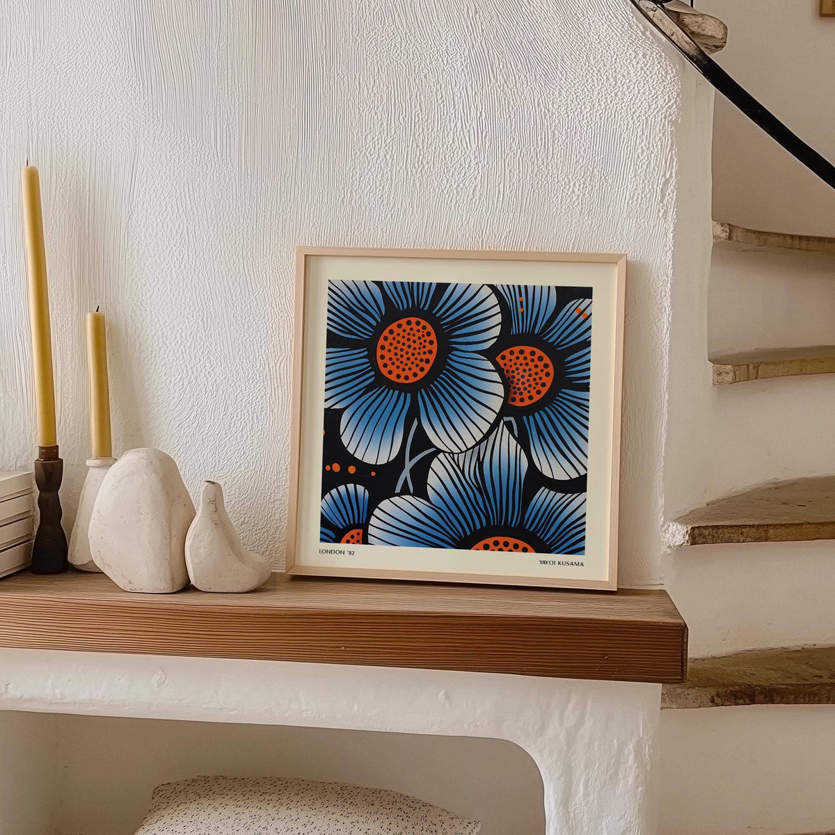 Blue flower wall art in pop art style with blue and orange flowers on a mantelpiece with candles