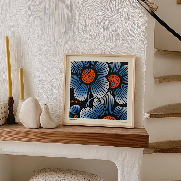 Blue flower wall art in pop art style with blue and orange flowers on a mantelpiece with candles