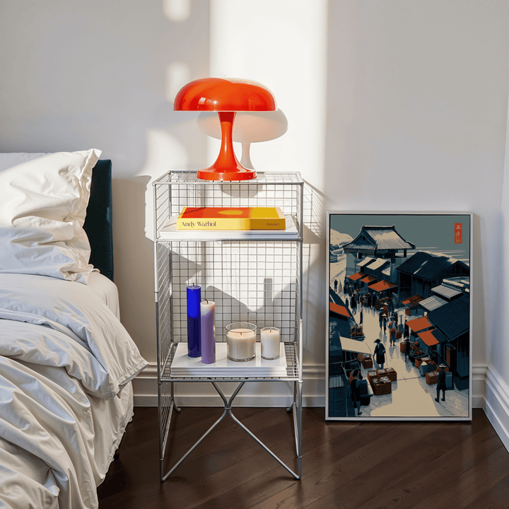 Asian Market wall art leaning beside a wire shelf with candles and an orange lamp in a bedroom