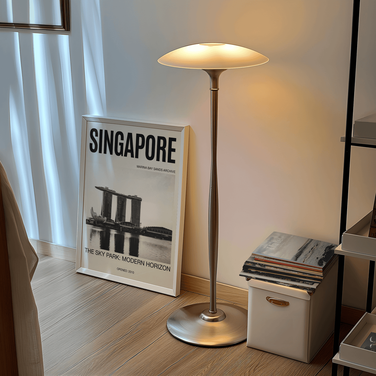 Singapore Modern Architecture Art Print leaning on a wooden floor lit by a nearby lamp with stacked books beside it
