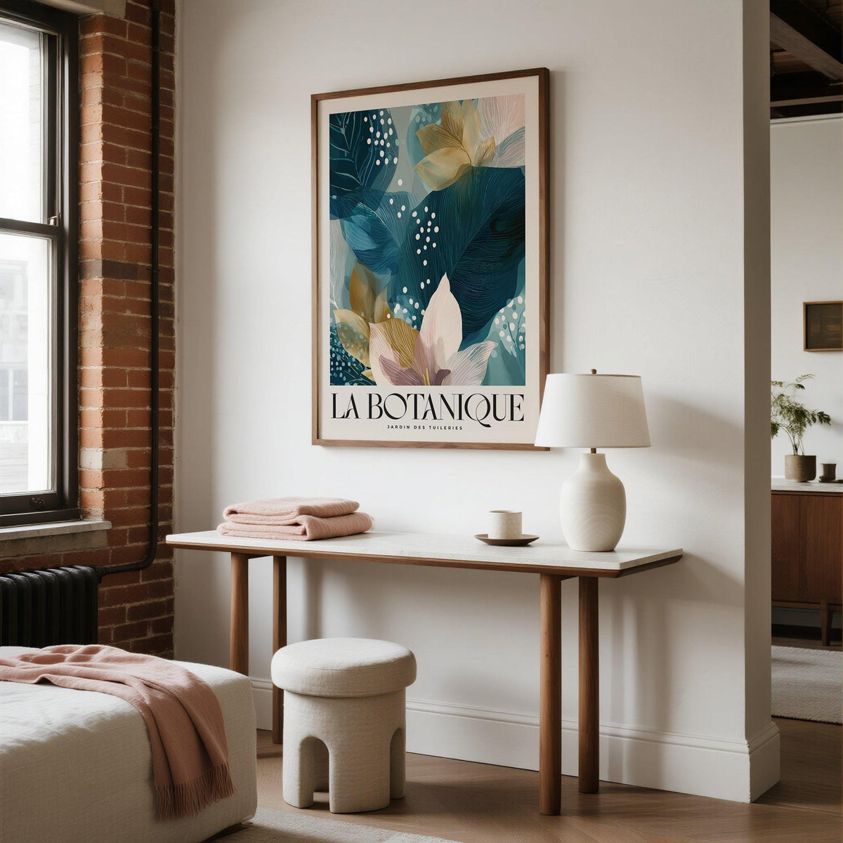 Botanical artwork print of blue leaves and flowers above a console table with a lamp in a living room