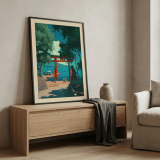 Print leaning on a shelf of a red torii gate by the sea in blue and green tones with a vase nearby