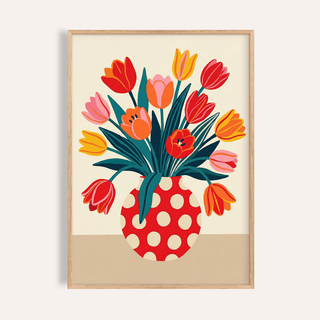 Framed floral art print of a tulip bouquet with orange yellow and pink flowers in a red polka dot vase