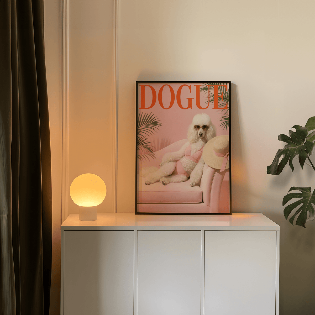 Pink Poodle Print leaning on a cabinet with a glowing spherical lamp and a green plant nearby