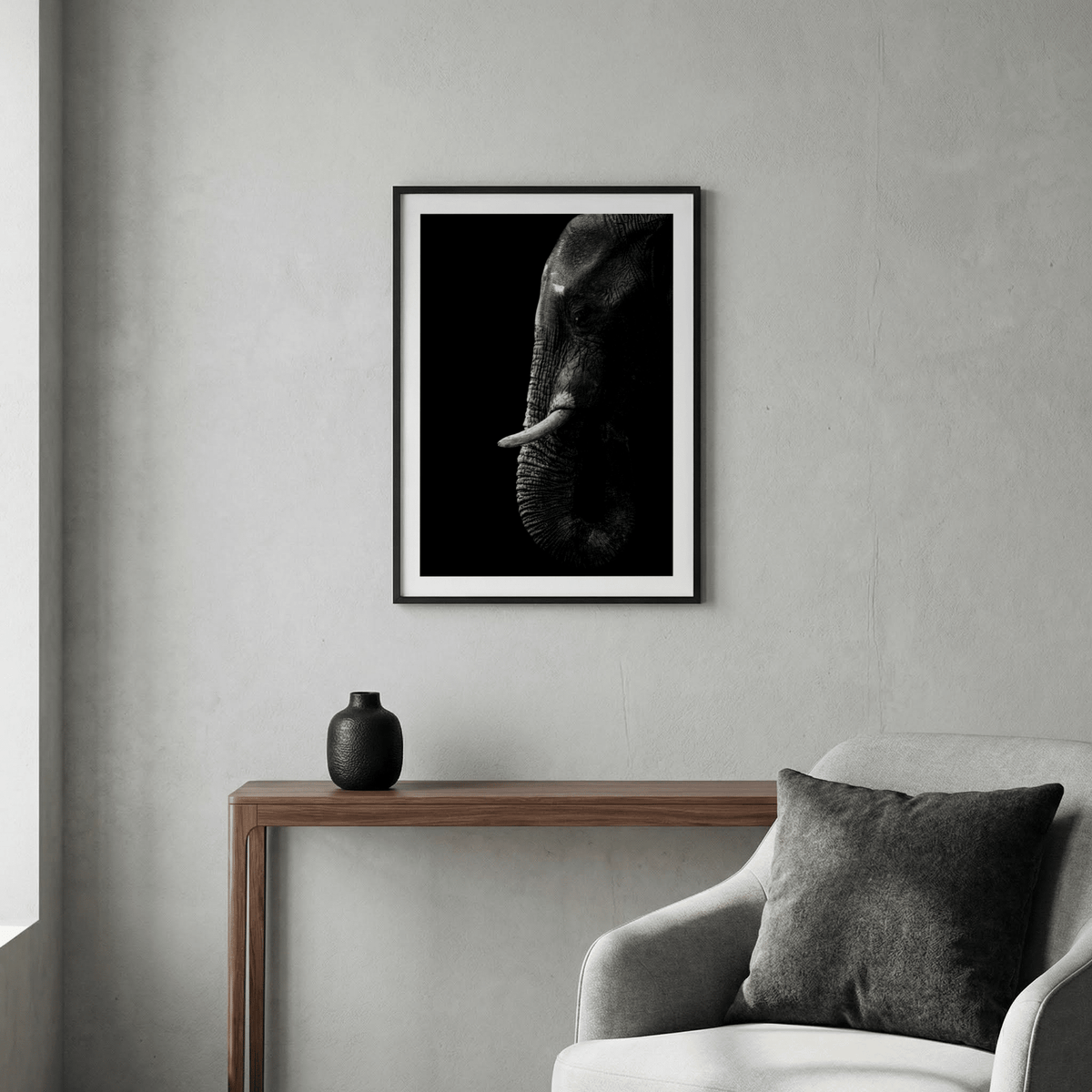 Black Elephant wall art of an elephant head in black and white hanging above a wooden console with a black vase
