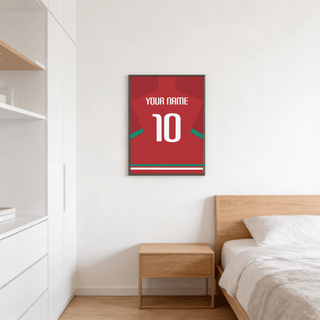 Football Shirt Poster in Red with Green Sleeve Stripe hanging above a wooden bedside table in a minimalist bedroom