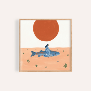 Framed print of surreal fish art print with woman in blue riding a blue and orange fish under a large red sun
