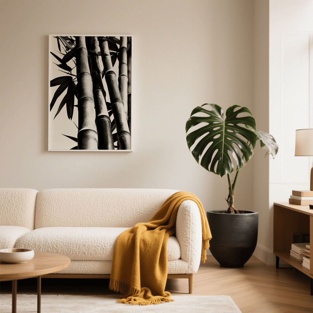 Bamboo Black And White Print on a beige wall above a white sofa with a mustard throw and a large potted plant nearby