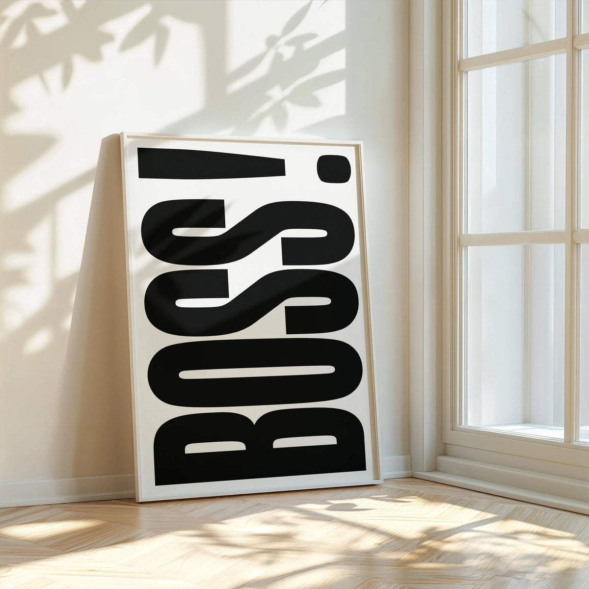 Print leaning against wall of boss typography in black and white with sunlight and shadows