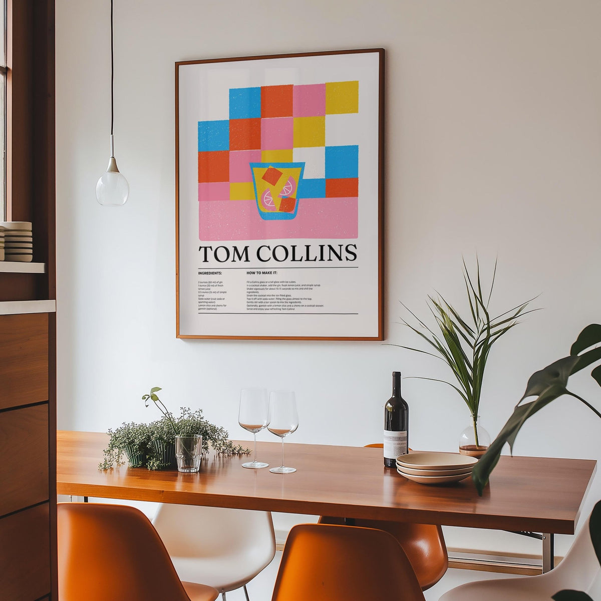 Print on a wall in a dining room featuring Tom Collins cocktail illustration with colourful blocks above a wooden table
