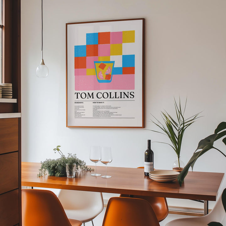 Print on a wall in a dining room featuring Tom Collins cocktail illustration with colourful blocks above a wooden table