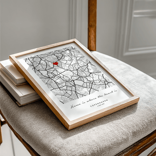 Framed Anniversary Map Print with black and grey city map and a red heart on a chair with textured cushion