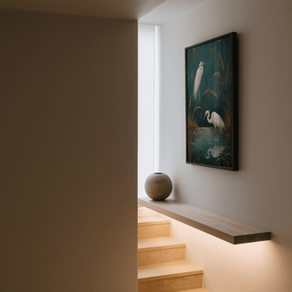 Egret Wall Art framed print with white birds and brown reeds above a wooden staircase with a round vase