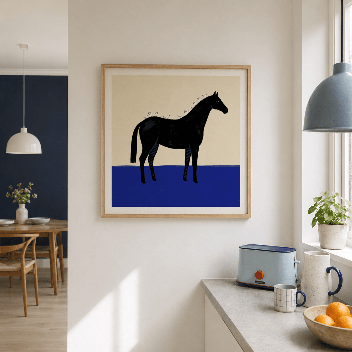 Black horse wall art with birds in minimalist style framed on a white wall in a kitchen with a toaster