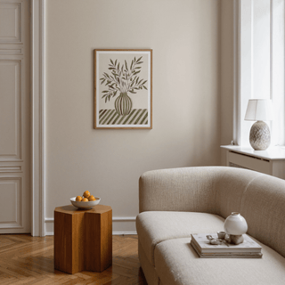 Olive Branch Art print on a beige wall with a cream sofa and wooden side table with fruit bowl