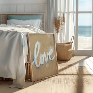 Love wall art leaning on a bedside basket with beige, white and blue tones in a bright bedroom