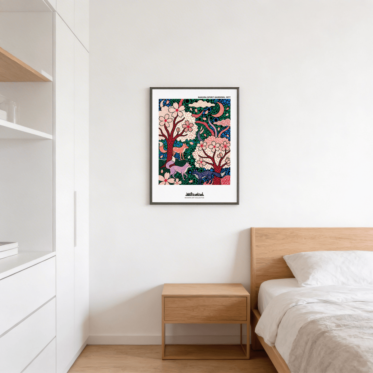 Print of foxes in a sakura garden with pink blossoms and green leaves above a wooden bedside cabinet in a bedroom