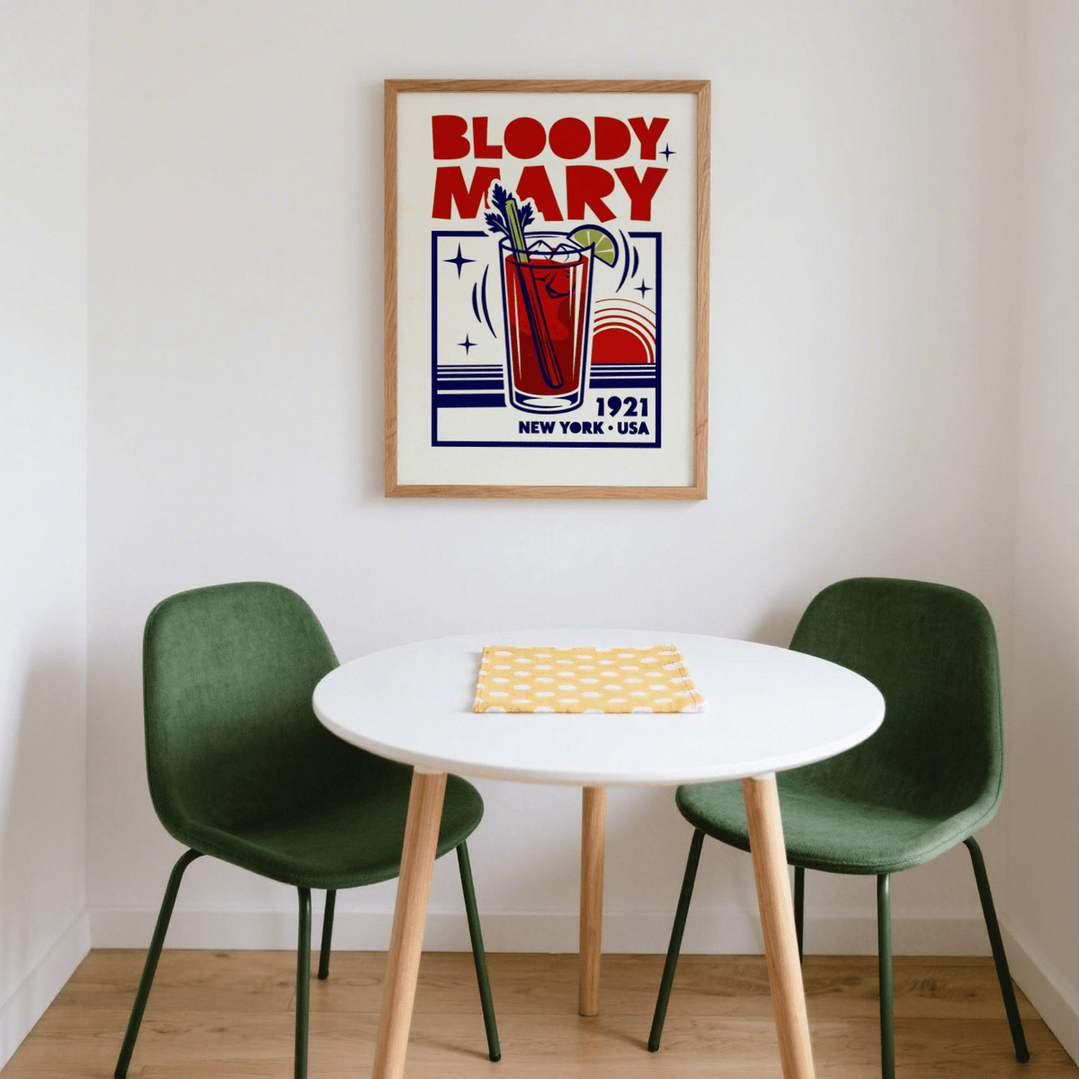 Bloody Mary poster on wall above a round white table with two green chairs and wooden floor