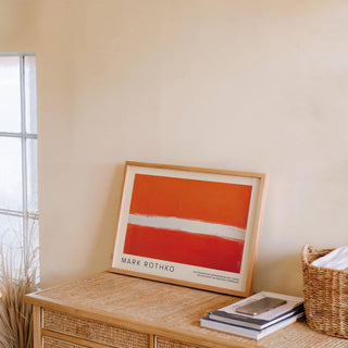 Orange Color Wall Art with orange red horizontal abstract resting on a wicker table near books and basket