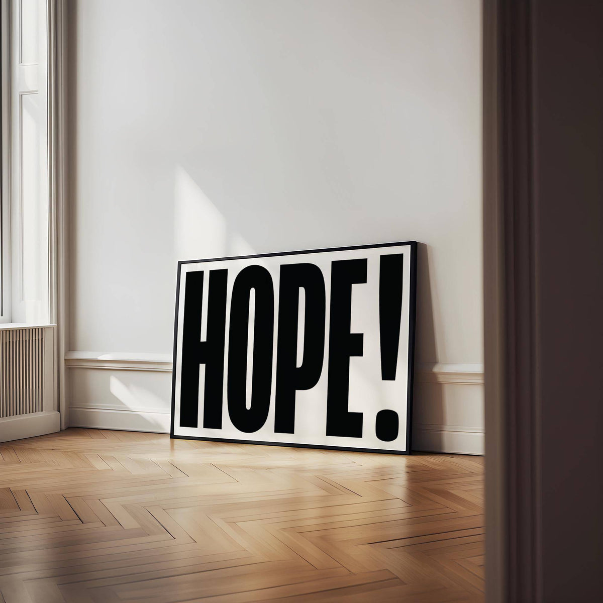 Motivational work posters print leaning on a wooden floor with large black hope typography