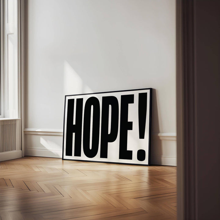 Motivational work posters print leaning on a wooden floor with large black hope typography