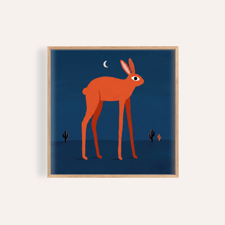 Framed print of orange rabbit wall art with dark blue background and moon