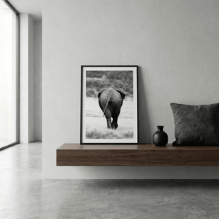 Nature Animal Wall Art of elephant rear view in black and white leaning on wooden shelf with a small black vase