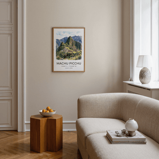 Machu Picchu art print framed on a beige wall above a wooden side table with a bowl of fruit in a living room