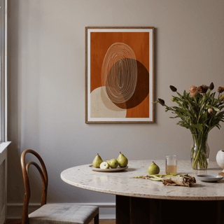 Modern Geometric Print of abstract concentric lines in warm rust and beige tones in a dining room with a table and flowers
