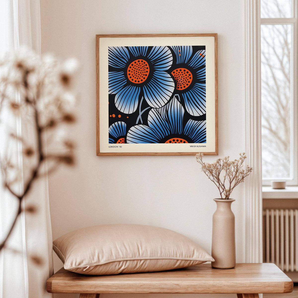 Blue Flower wall art with blue and orange pop-art flowers above a beige cushion on a wooden bench