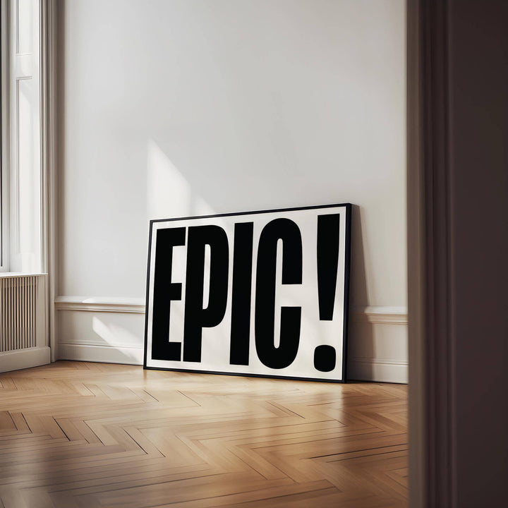 Big Text Sign wall art of the word EPIC in black and white leaning on a wooden floor in a bright room near a window