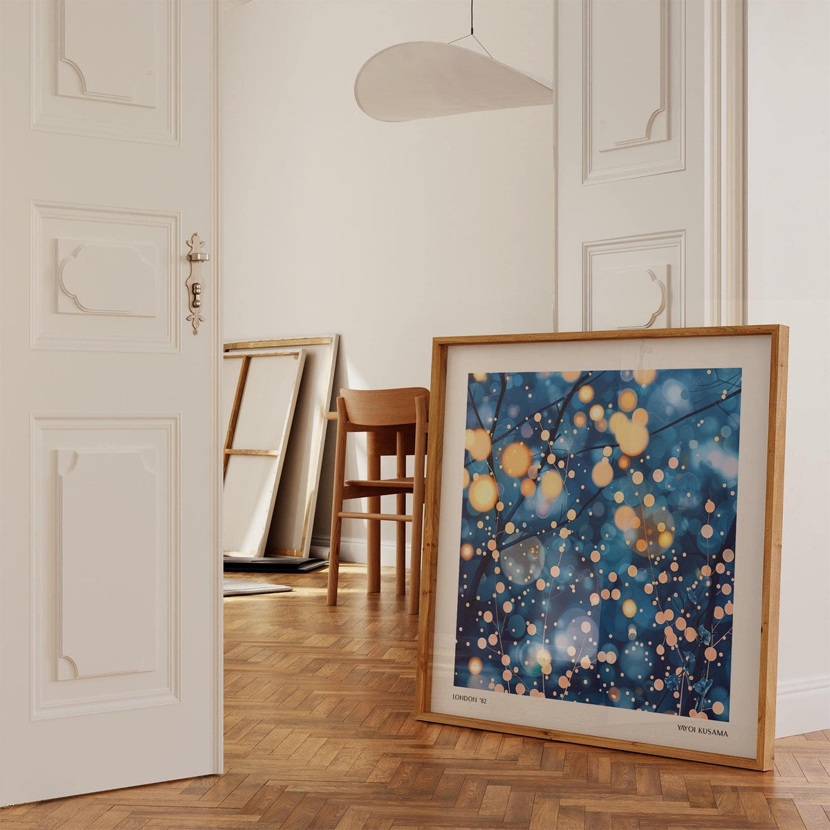 Modern Painting Prints leaning on floor with warm light branches and blue background in a room