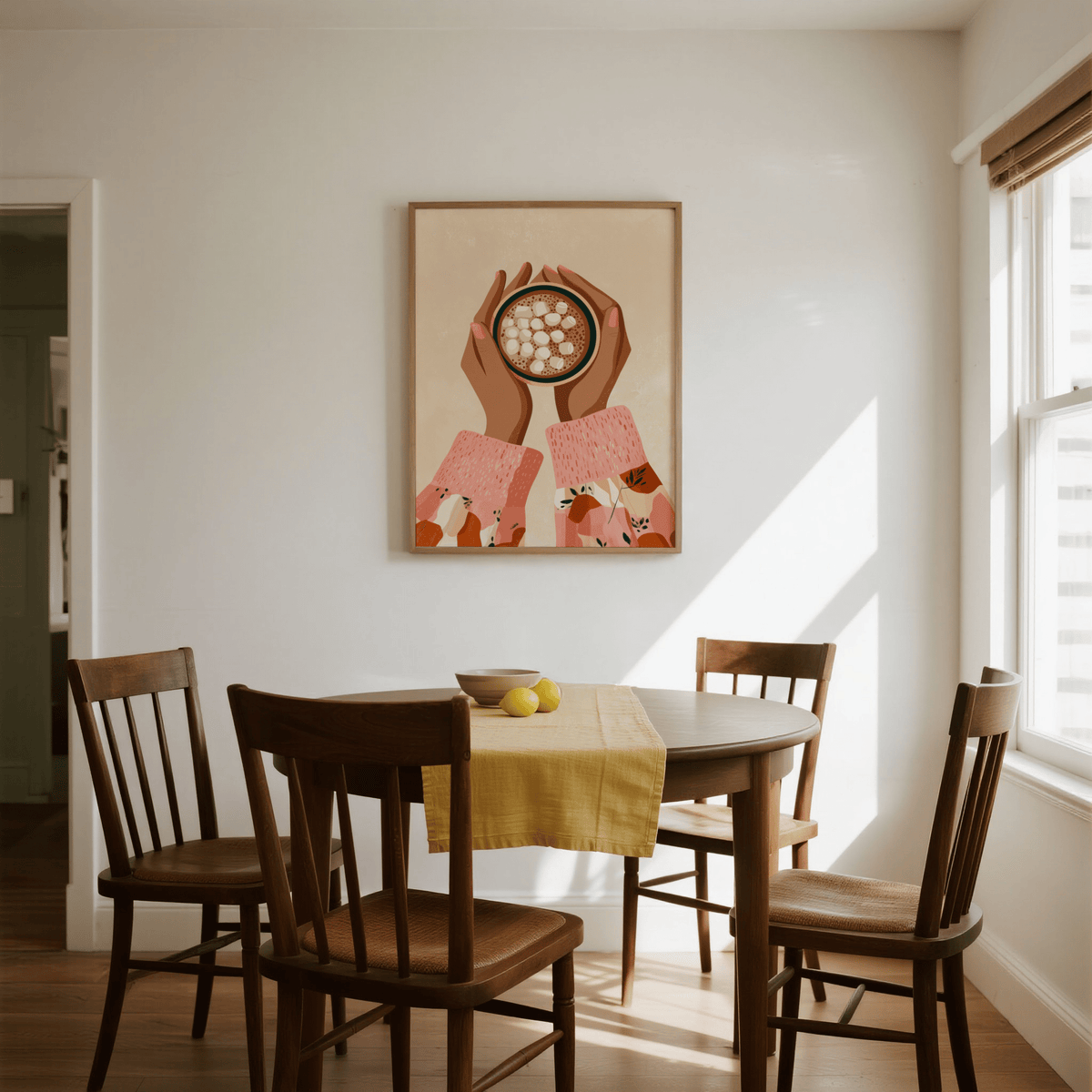 Hot Cocoa wall art illustration with warm brown and pink tones above a wooden dining table in natural light