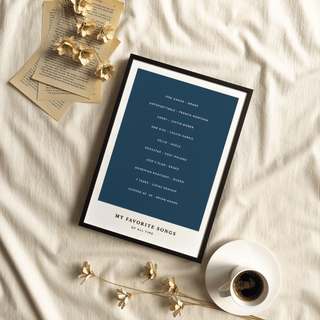 Framed close-up of custom song wall art with white text on navy and black frame on fabric
