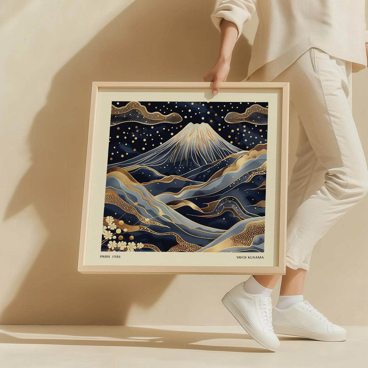 Framed Blue and Gold Wall Art held by a person showing Mount Fuji illustration with gold accents