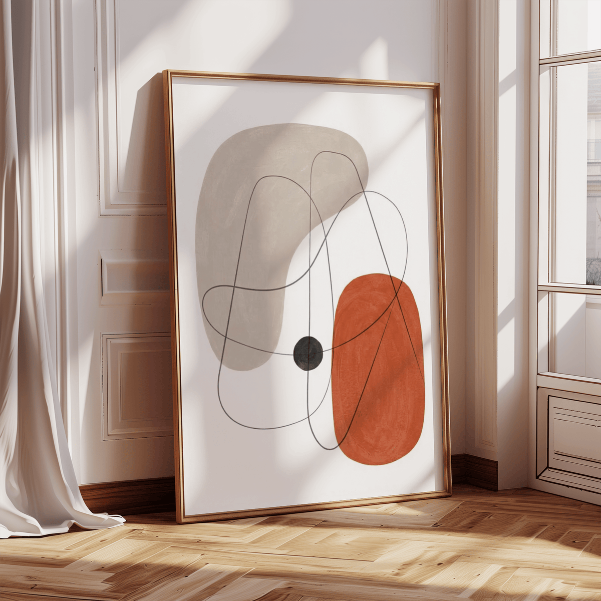 Print leaning on a floor showing an abstract wall poster with beige and terracotta shapes and thin black lines near a window