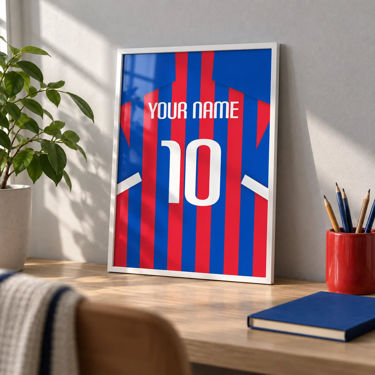 Football Shirt Poster in Blue and Red Stripes, a small A4 framed print leaning on a pale oak desk