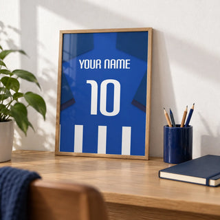 Football Shirt Poster in Blue and White Stripes with Dark Blue Sleeves, a small A4 framed print leaning on an oak desk